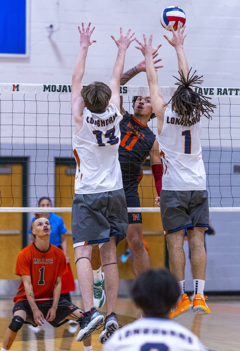 Mojave's Albert "AJ" Tuitele (11) spikes the ball against Legacy's Cambel Tolman (13) ...
