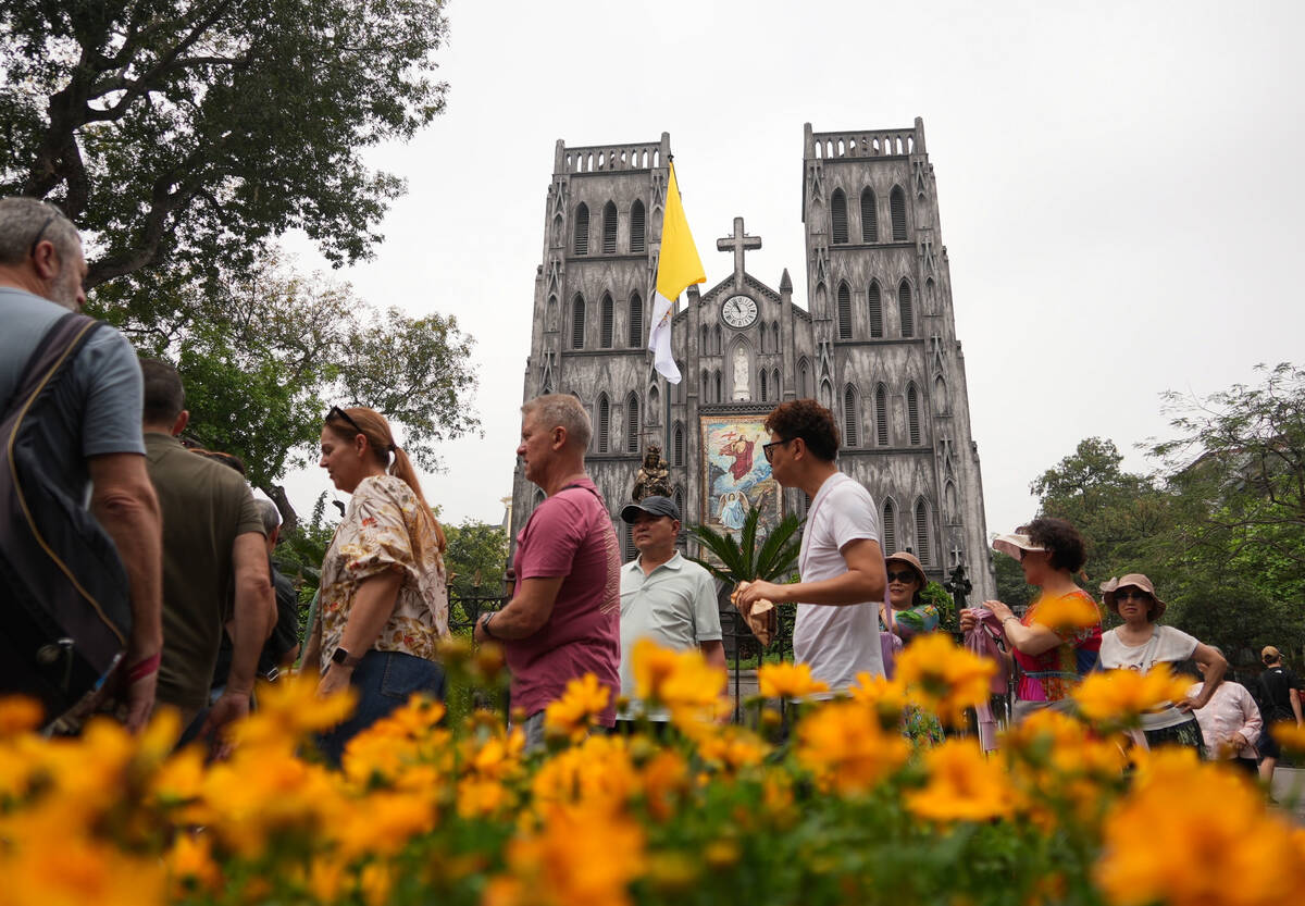 Tourists visit the St. Joseph's Cathedral in Hanoi, Vietnam, Tuesday, April 22, 2025. (AP Photo ...