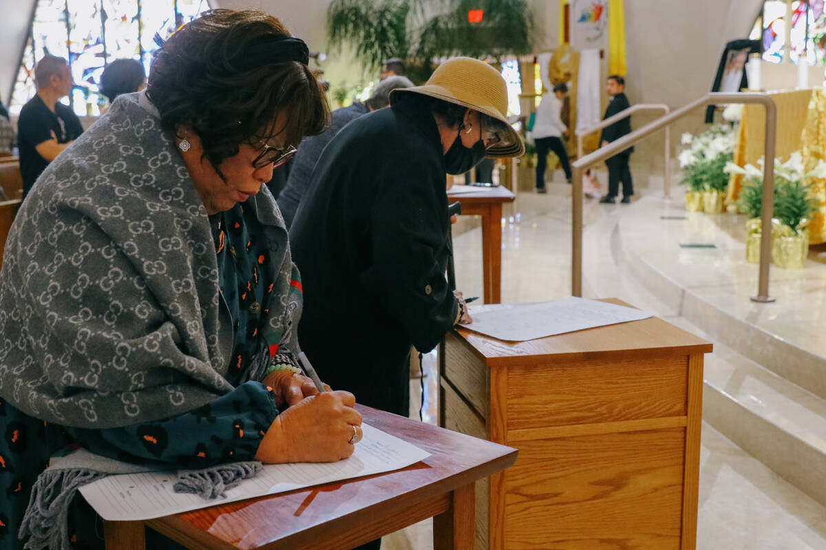Congregants write personal messages to Pope Francis after a memorial Mass for him on Friday, A ...