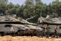Israeli soldiers clean the gun of a tank at a position near Israel's border with the Gaza Srip ...