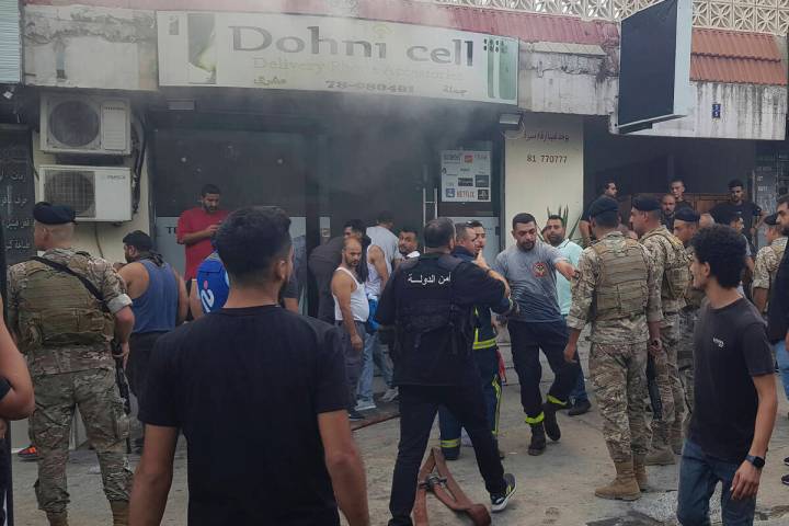 Lebanese soldiers and firefighters gather outside a mobile shop after what is believed to be th ...
