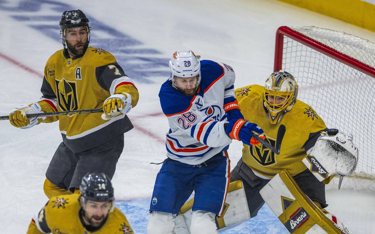 Golden Knights goaltender Adin Hill (33) just deflects the puck off of his glove as Edmonton Oi ...