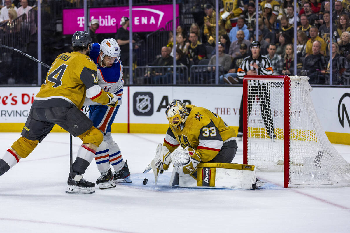 Golden Knights goaltender Adin Hill (33) stops a shot as Edmonton Oilers center Mattias Janmark ...