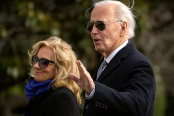 President Joe Biden gestures as he and first lady Jill Biden walk across the South Lawn of the ...