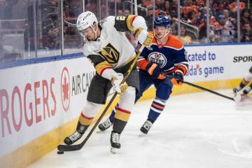Vegas Golden Knights' Zach Whitecloud (2) is chased by Edmonton Oilers' Trent Frederic (21) dur ...