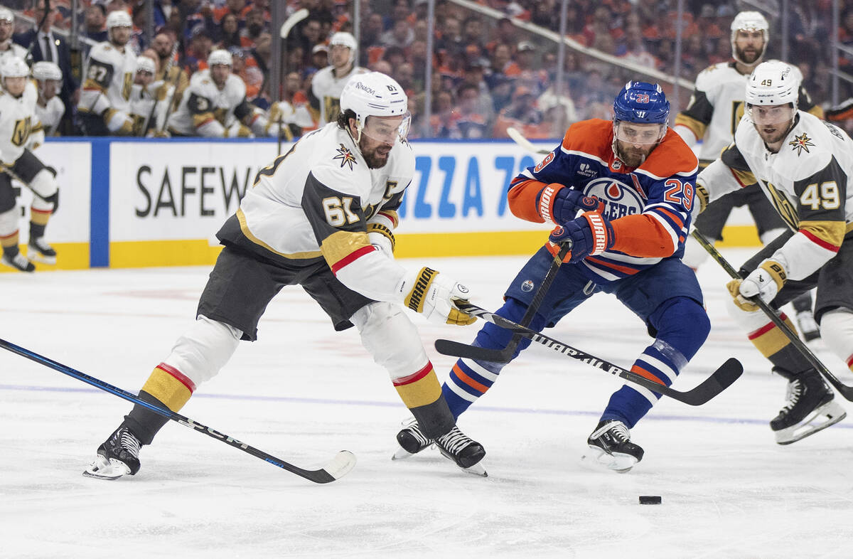 Vegas Golden Knights' Mark Stone (61) and Edmonton Oilers' Leon Draisaitl (29) battle for the p ...