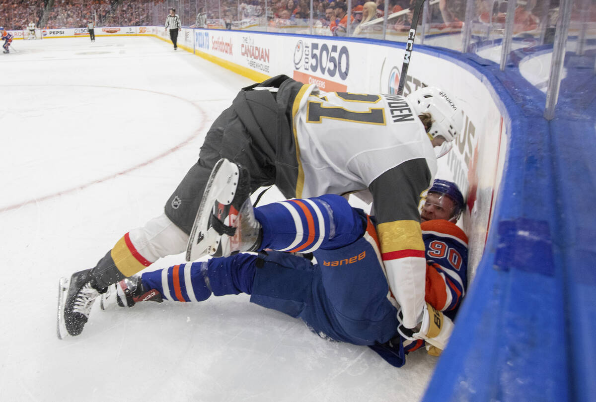 Vegas Golden Knights' Brett Howden (21) and Edmonton Oilers' Corey Perry (90) rough it up durin ...