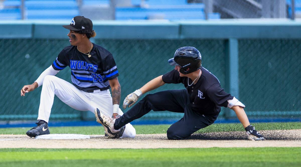 Faith Lutheran runner Ace Hansen (1) slides safely into third base as a the throw goes past Ba ...