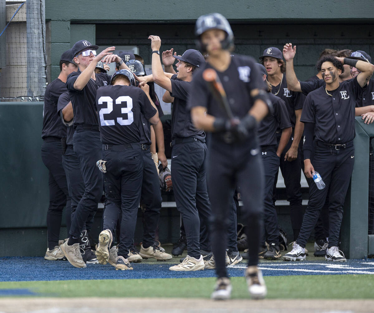 Faith Lutheran players celebrate runner Macen Collura (23) after scoring against Reno during da ...
