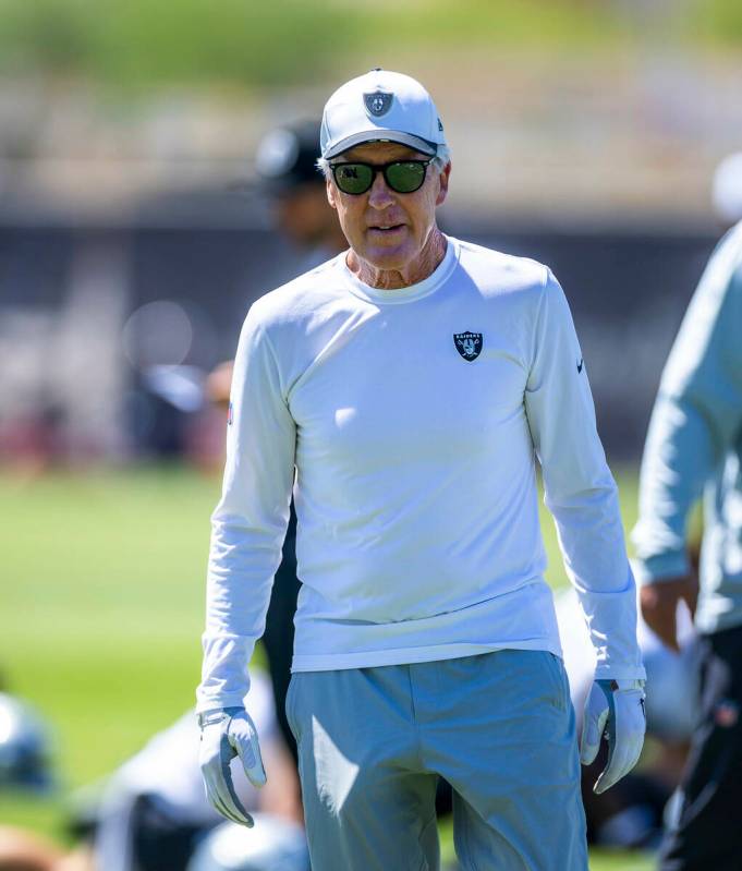 Raiders head coach Pete Carroll walks about his players in warm ups during Raiders OTA practice ...