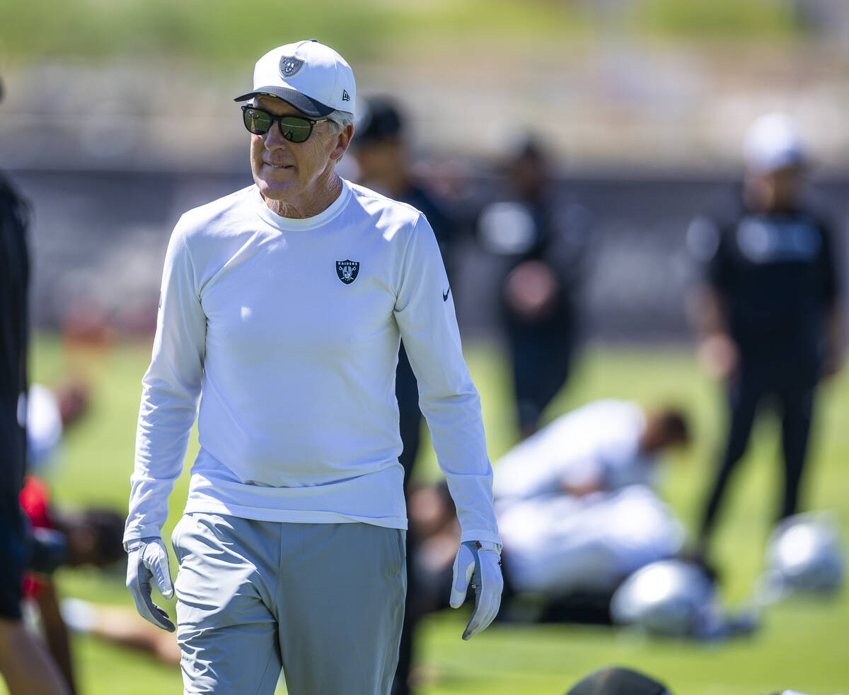 Raiders head coach Pete Carroll walks about his players in warm ups during Raiders OTA practice ...