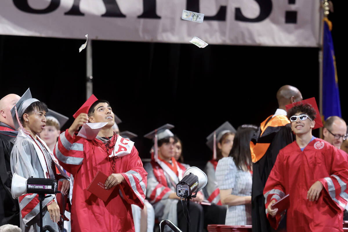 An Arbor View High School student tosses bills in the air after receiving their diploma during ...