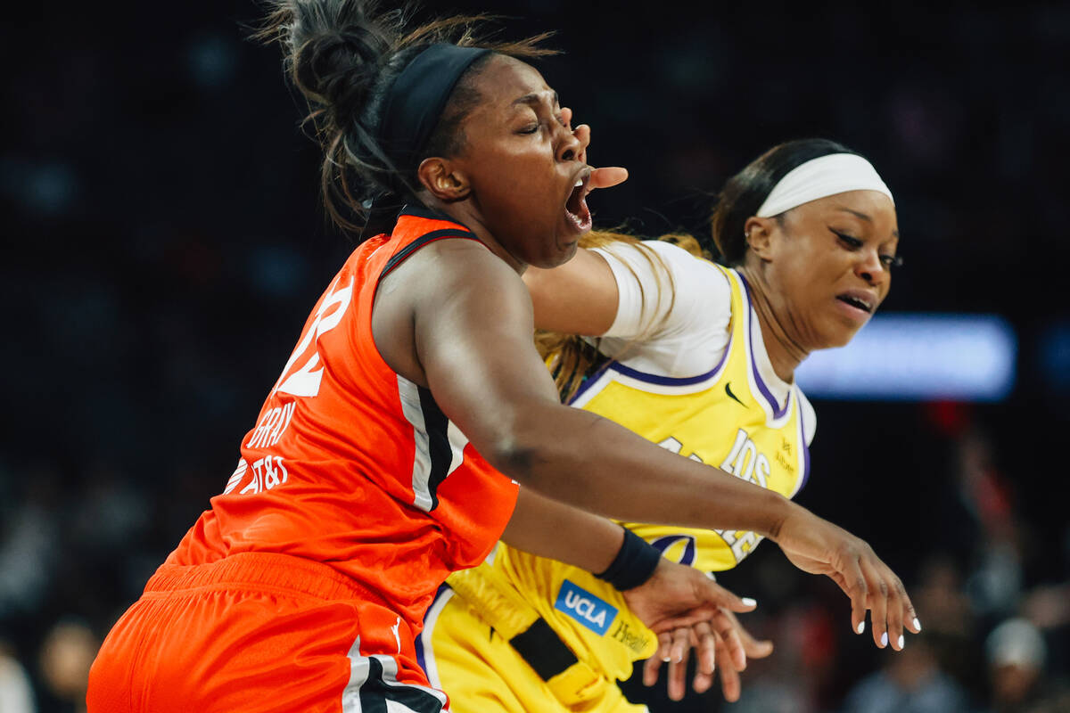 Aces guard Chelsea Gray (12) takes a hand to the face during a WNBA basketball game between the ...