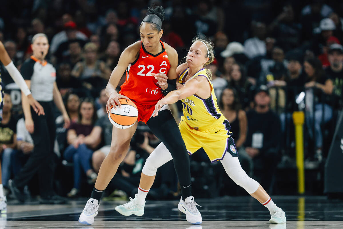 Aces center A'ja Wilson (22) dribbles the ball as Los Angeles Sparks guard Julie Allemand (20) ...